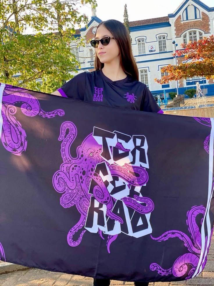 Aluna segurando bandeira roxa do terceirão com ilustração de polvo