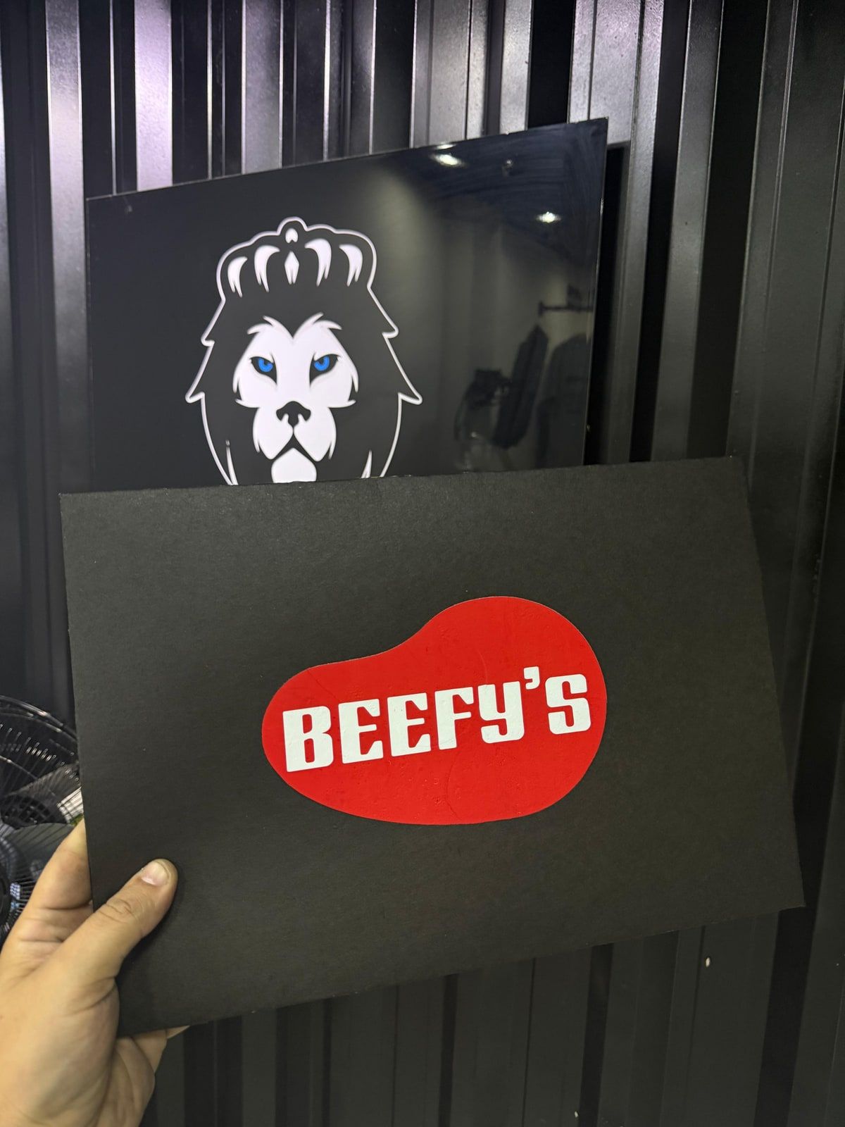 Placa preta com a logo vermelha da Beefy's