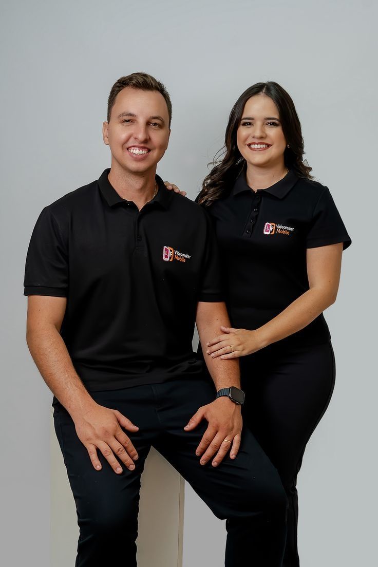 Homem e mulher vestindo camisas polo pretas com logo no peito